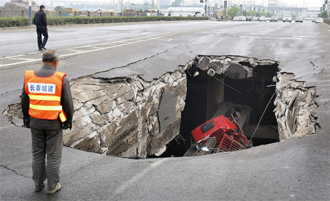 A truck is seen in a hole after part of the structure of a bridge collapsed into a river in Changchun, Jilin province May 29, 2011. epa