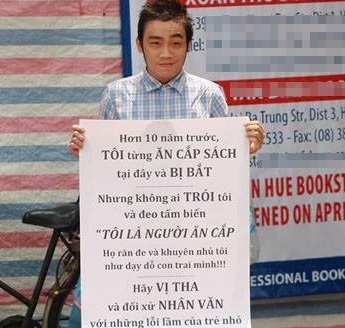Chàng trai cầm biển phản đối vụ nữ sinh bị đeo bảng ăn cắp