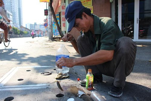 Người Sài Gòn ngồi giữa đường phố để câu cá trên nắp cống