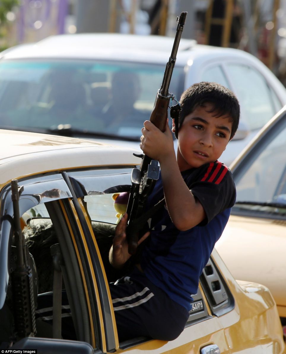 Cậu bé này được trang bị súng và sẵn sàng tham gia lực lượng an ninh Iraq để chống lại các chiến binh Jihad