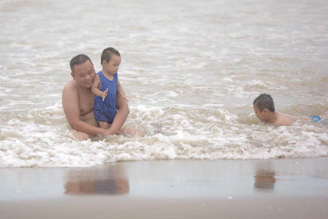 Chùm ảnh: Bất chấp sóng to gió lớn sau bão số 2, nhiều gia đình vẫn đưa trẻ em ra tắm biển Cửa Lò - Ảnh 5.