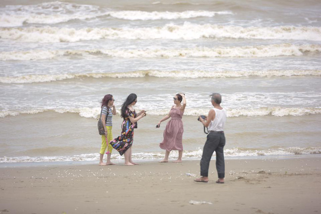 Chùm ảnh: Bất chấp sóng to gió lớn sau bão số 2, nhiều gia đình vẫn đưa trẻ em ra tắm biển Cửa Lò - Ảnh 1.
