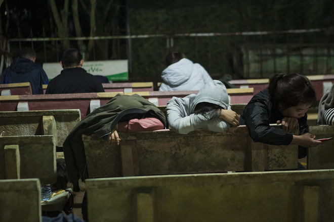 Người phụ nữ mặc áo mưa, ngủ qua đêm trên ghế đá chờ xin ấn đền Trần 3