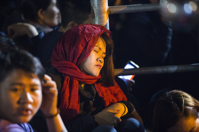 Người phụ nữ mặc áo mưa, ngủ qua đêm trên ghế đá chờ xin ấn đền Trần 13