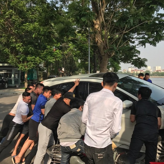 Hà Nội: Hàng chục thanh niên khiêng xe giải cứu người phụ nữ bị mắc kẹt sau cú mất lái lao lên vỉa hè - Ảnh 1.
