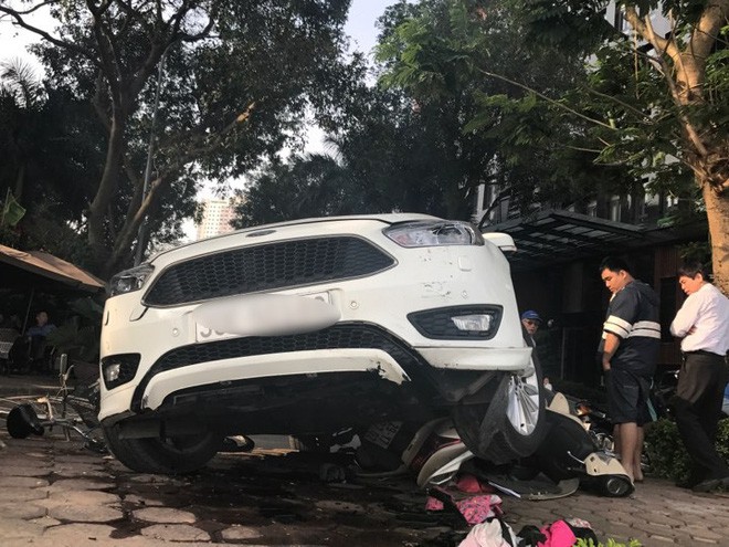 Hà Nội: Hàng chục thanh niên khiêng xe giải cứu người phụ nữ bị mắc kẹt sau cú mất lái lao lên vỉa hè - Ảnh 2.