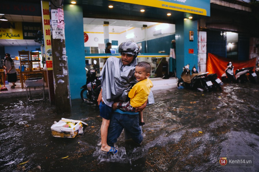 Phụ huynh ẵm bồng con nhỏ, bì bõm lội nước về nhà sau con mưa lớn ở Sài Gòn - Ảnh 8.