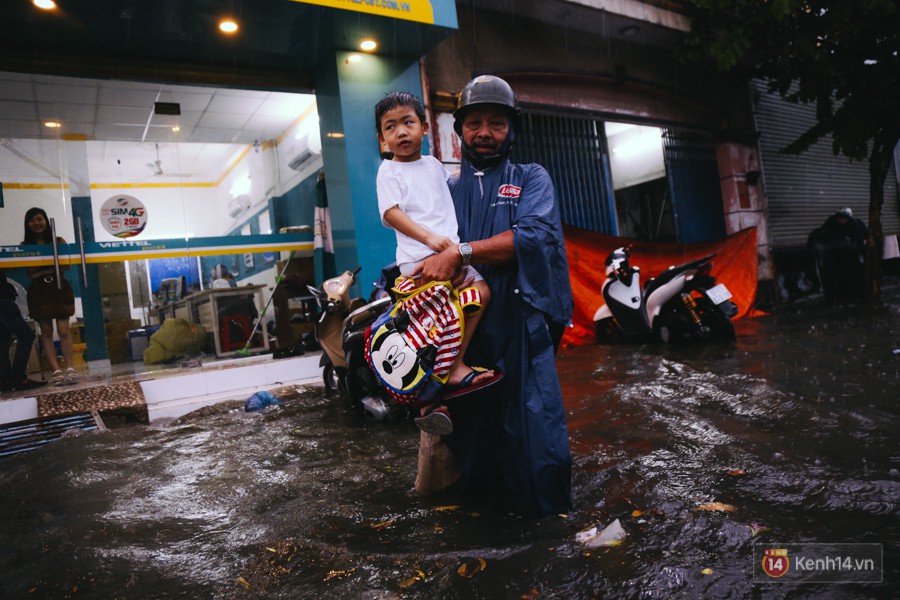 Phụ huynh ẵm bồng con nhỏ, bì bõm lội nước về nhà sau con mưa lớn ở Sài Gòn - Ảnh 7.
