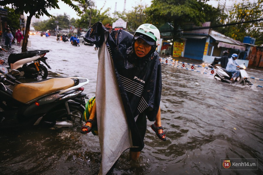 Phụ huynh ẵm bồng con nhỏ, bì bõm lội nước về nhà sau con mưa lớn ở Sài Gòn - Ảnh 6.
