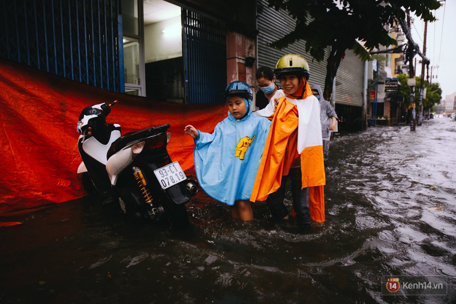 Phụ huynh ẵm bồng con nhỏ, bì bõm lội nước về nhà sau con mưa lớn ở Sài Gòn - Ảnh 16.