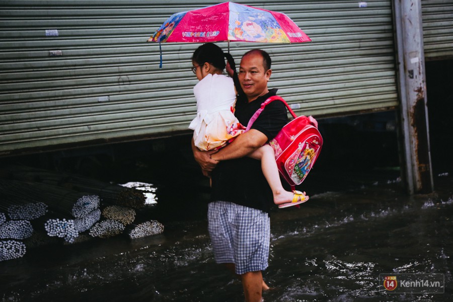 Phụ huynh ẵm bồng con nhỏ, bì bõm lội nước về nhà sau con mưa lớn ở Sài Gòn - Ảnh 15.