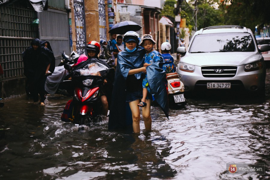 Phụ huynh ẵm bồng con nhỏ, bì bõm lội nước về nhà sau con mưa lớn ở Sài Gòn - Ảnh 14.