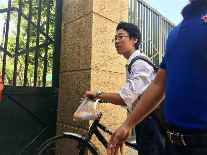 Xót xa cảnh nam sinh tự đạp xe đến trường thi với chiếc bánh mỳ mua vội treo trên ghi-đông chưa kịp ăn - Ảnh 1.