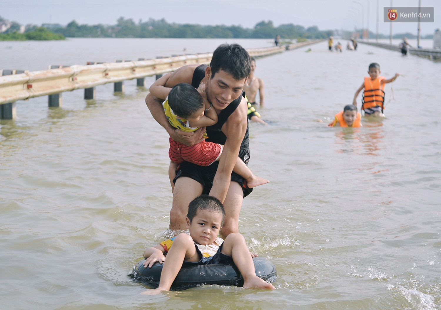 Chùm ảnh: Người lớn, trẻ nhỏ Hà Nội mặc áo phao ùa ra đường tỉnh lộ bơi lội, đánh cá sau nhiều ngày mưa ngập - Ảnh 10.