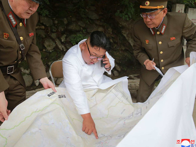 Triều Tiên lần đầu công bố hình ảnh gây sốt: Nhà lãnh đạo Kim Jong-un dầm mưa đi thị sát - Ảnh 12.