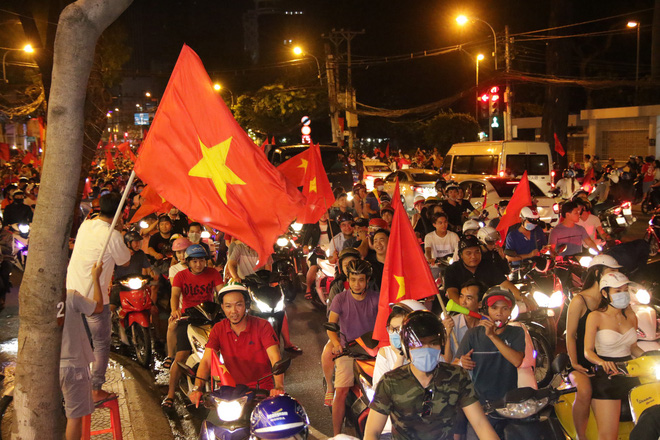 Người Sài Gòn bất chấp nguy hiểm leo lên nóc xe mừng chiến thắng của U23 Việt Nam - Ảnh 1.