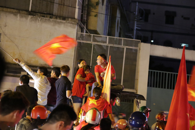 Người Sài Gòn bất chấp nguy hiểm leo lên nóc xe mừng chiến thắng của U23 Việt Nam - Ảnh 10.