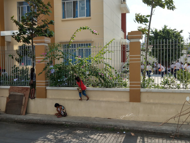 Hình ảnh 3 em nhỏ bán vé số bám hàng rào trường học để xem khai giảng gây xúc động mạnh - Ảnh 1.