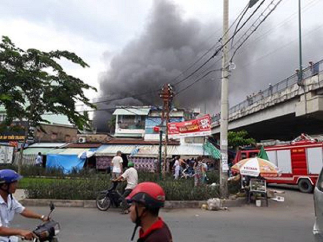 Đang cháy lớn nhiều nhà dân ở gần cầu Bình Lợi, khói đen bốc cao nghi ngút - Ảnh 1.