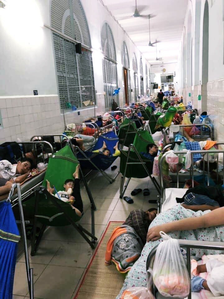 Xót xa hình ảnh người lớn và trẻ em trải chiếu, mắc võng nằm chật kín hành lang bệnh viện ở Sài Gòn - Ảnh 1.