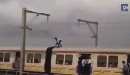 Thanh niên đứng trên nóc tàu hỏa né đường điện cao thế y như phim hành động