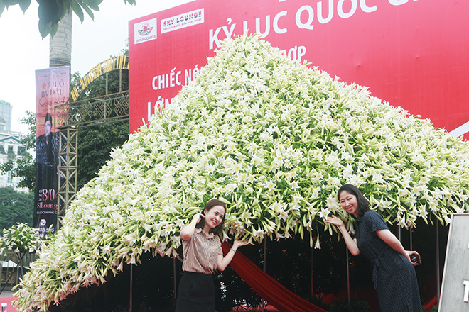 Chị em thích thú với mô hình nón lá khổng lồ bằng hoa loa kèn trên phố Hà Nội 1