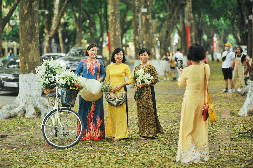 Chị em thích thú với mô hình nón lá khổng lồ bằng hoa loa kèn trên phố Hà Nội 5 Chị em thích thú với mô hình nón lá khổng lồ bằng hoa loa kèn trên phố Hà Nội 5