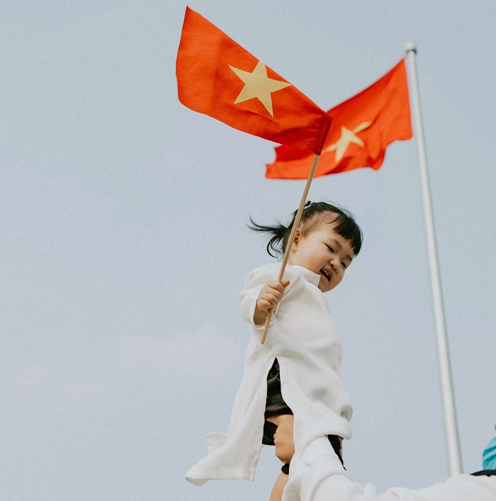 Em bé Việt Nam mặc áo dài trắng, cầm cờ đỏ sao vàng giữa tâm dịch: Cố lên Việt Nam ơi! 2 Em bé Việt Nam mặc áo dài trắng, cầm cờ đỏ sao vàng giữa tâm dịch: Cố lên Việt Nam ơi! 2