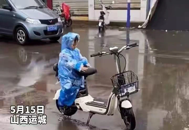 Đợi mẹ giữa trời mưa, cậu bé dùng thân che yên xe để mẹ ngồi không bị ướt 1 Đợi mẹ giữa trời mưa, cậu bé dùng thân che yên xe để mẹ ngồi không bị ướt 1