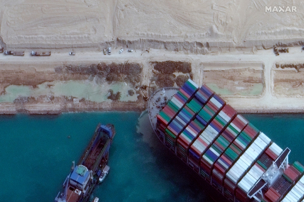 Tàu kéo và máy đào tiếp tục đẩy và kéo tàu container Ever Given trong khi nó còn mắc kẹt. Ảnh: AP Tàu kéo và máy đào tiếp tục đẩy và kéo tàu container Ever Given trong khi nó còn mắc kẹt. Ảnh: AP